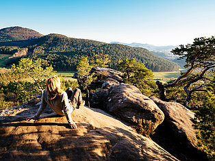 Frau liegt auf Felsen und genießt die Aussicht 